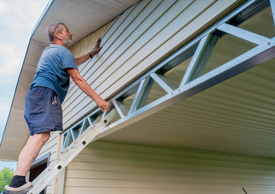 professional siding contractor working on commercial siding 